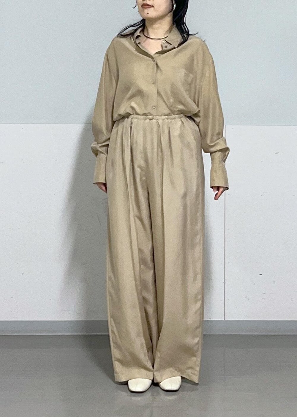 シルバー系のトートバッグ、ベージュ系のシャツ/ブラウス、ブラウン系のTシャツ/カットソーを着用したレディースの春コーディネートの4枚目の写真