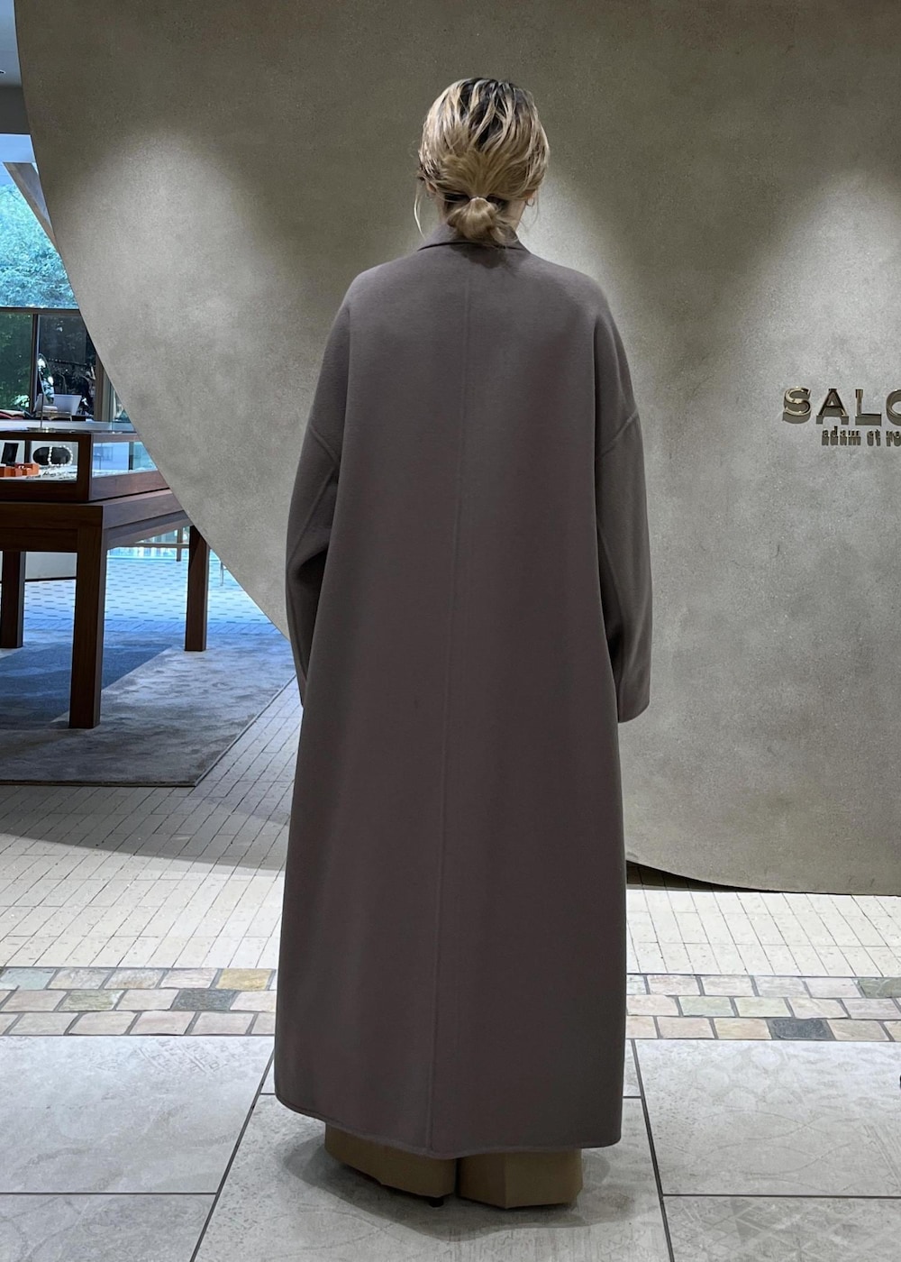 ベージュ系のスラックス、ベージュ系のチェスターコート、ホワイト系のニット/セーターを着用したレディースの秋コーディネートの6枚目の写真