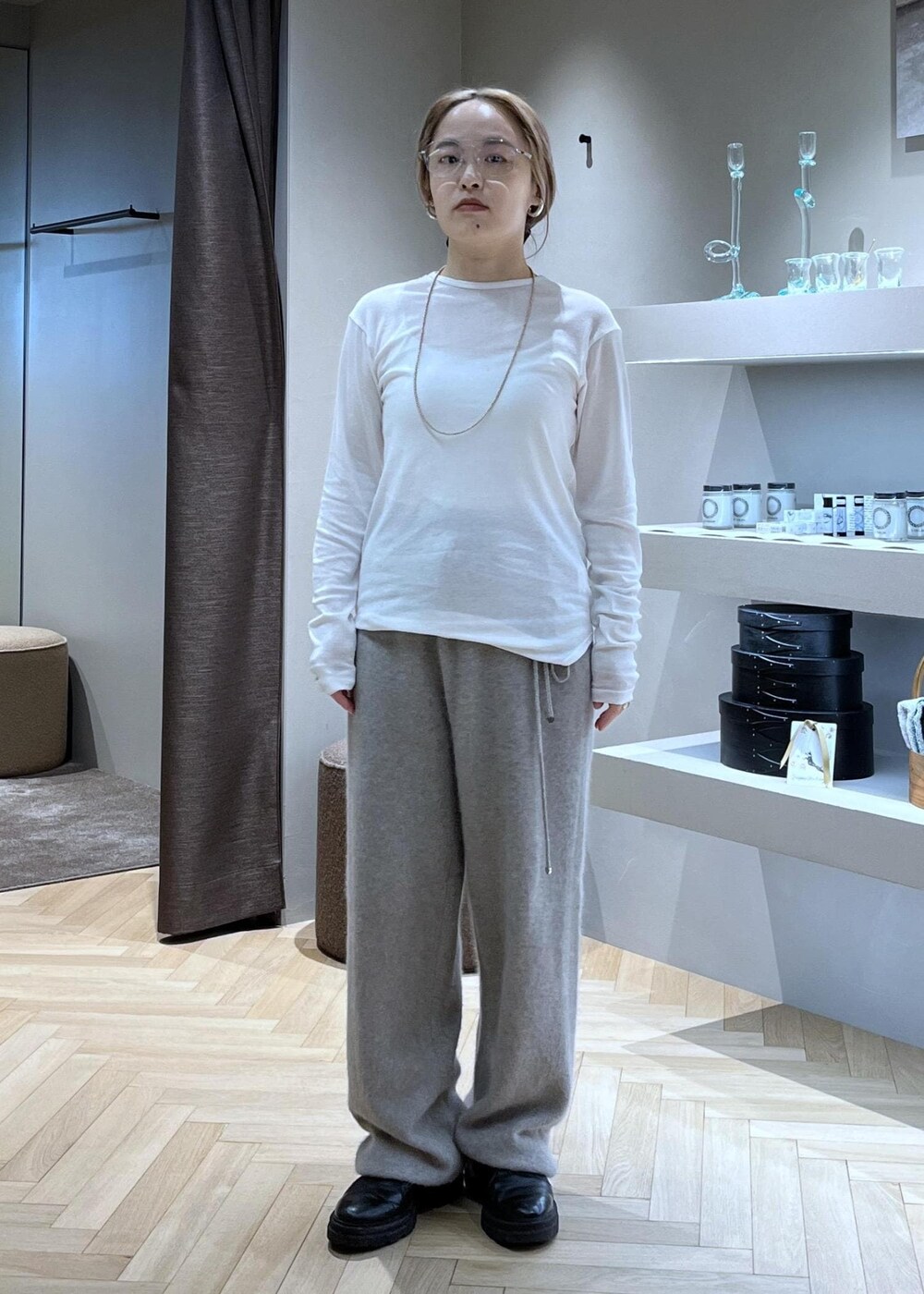 ブラック系のブーツ、ベージュ系のカーディガン/ボレロ、グレー系のトレンチコートを着用したレディースの冬コーディネートの8枚目の写真