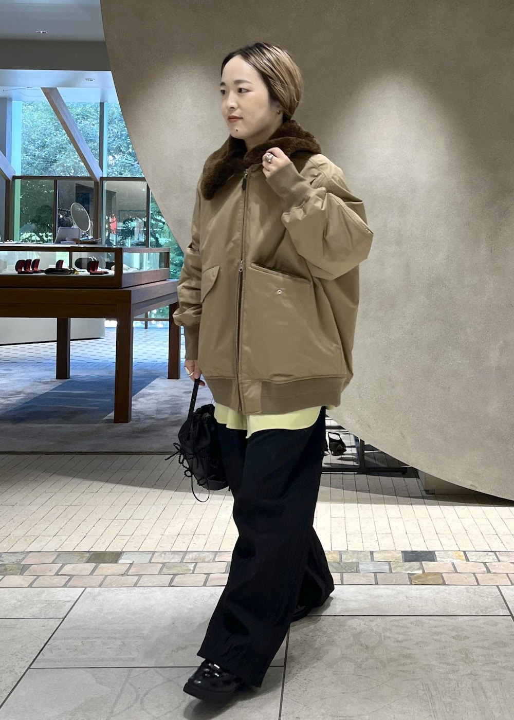 ブラック系のその他パンツ、ベージュ系のショルダーバッグを着用したレディースの秋コーディネートの5枚目の写真