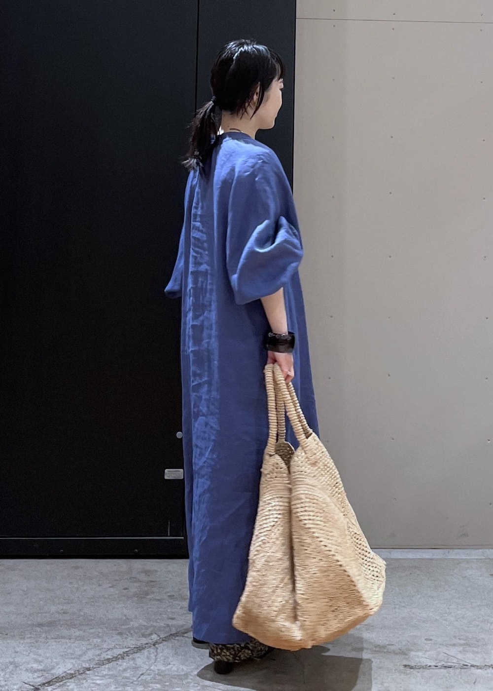 グレー系のその他パンツ、ホワイト系のかごバッグ、ブルー系のワンピースを着用したレディースの春コーディネートの3枚目の写真