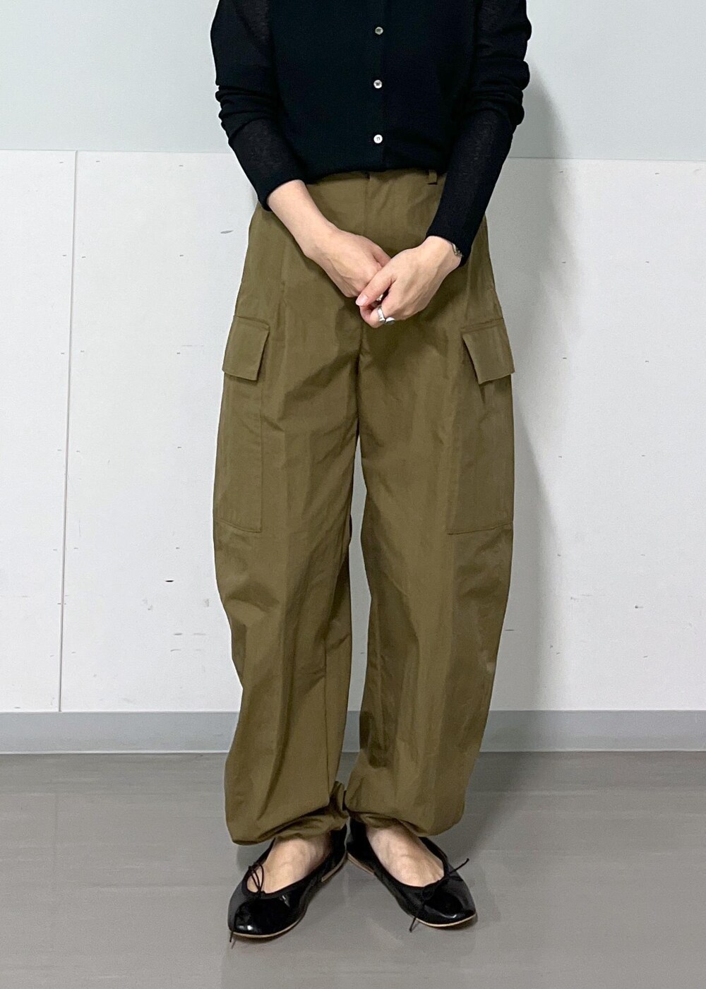 グリーン系のカーゴパンツ、ブラック系のハンドバッグ、ブラック系のカーディガン/ボレロを着用したレディースの夏コーディネートの6枚目の写真