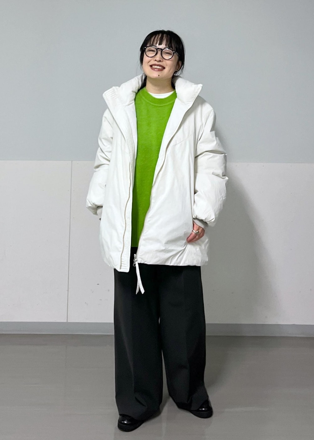 グレー系のその他パンツ、ホワイト系のダウンジャケット/コート、ホワイト系のTシャツ/カットソーを着用したレディースの秋コーディネートの2枚目の写真