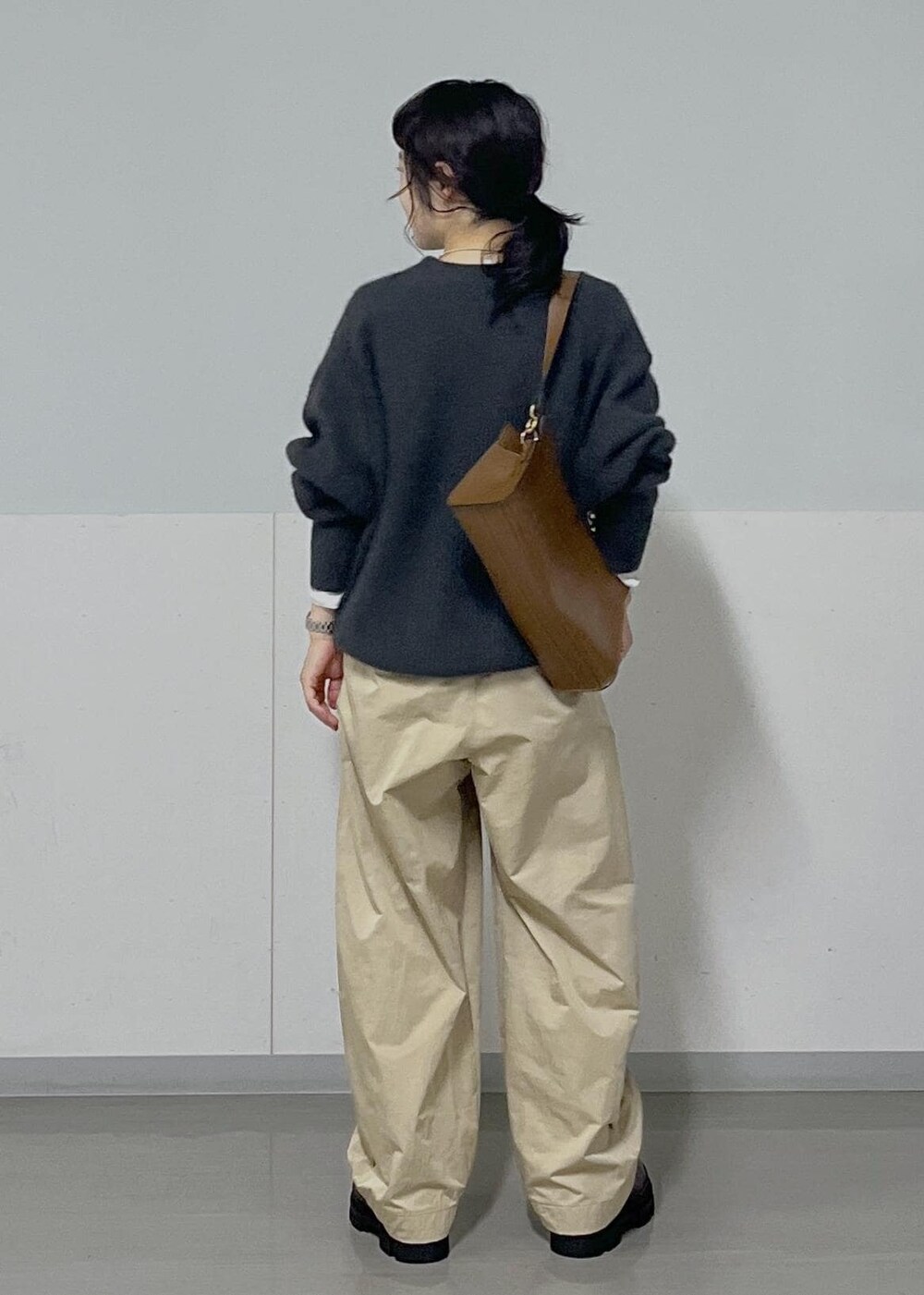 ホワイト系のTシャツ/カットソー、ブラウン系のショルダーバッグ、グレー系のニット/セーターを着用したレディースの秋コーディネートの4枚目の写真