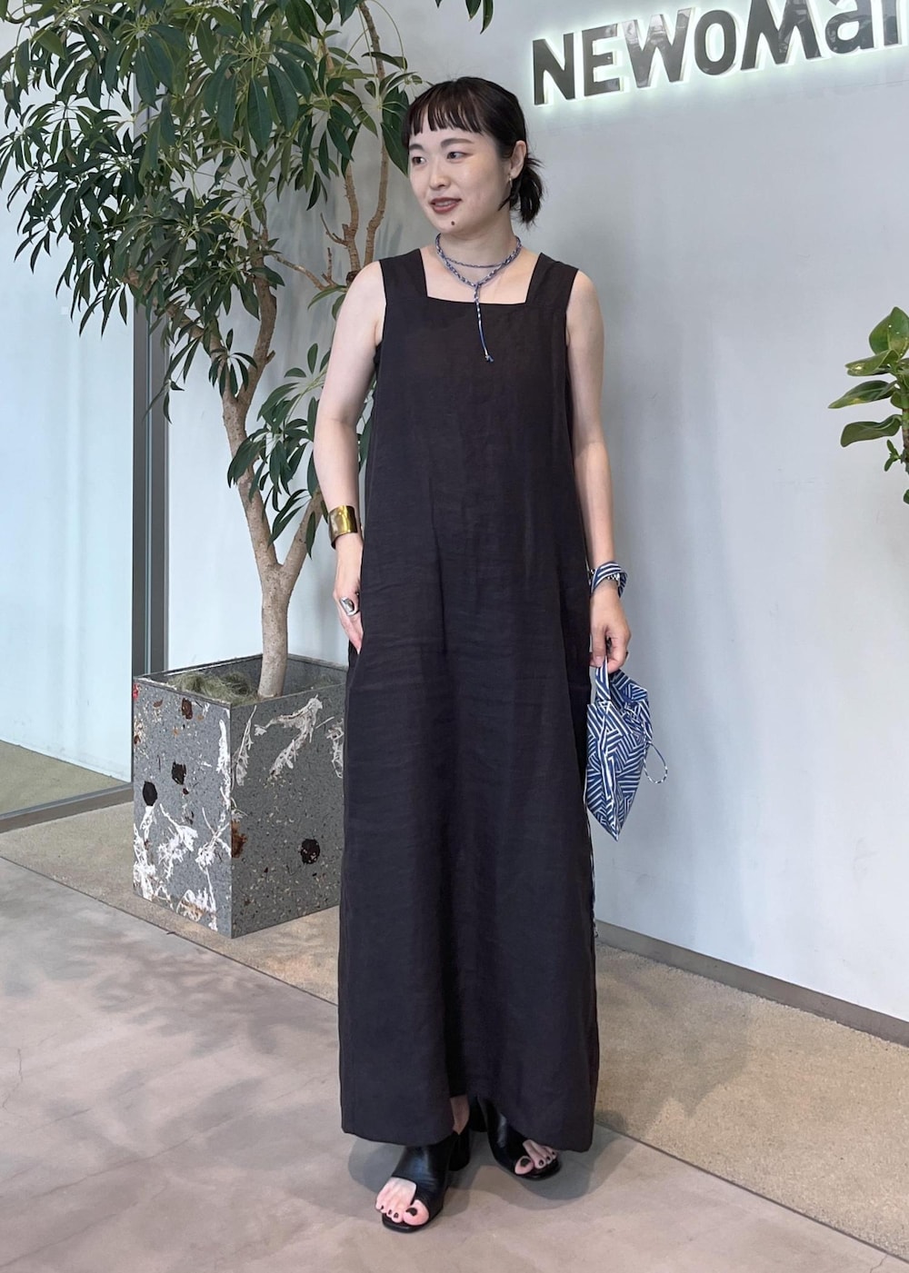 グレー系のカーディガン/ボレロ、ブラウン系のトートバッグ、ブラック系のジャンパースカートを着用したレディースの夏コーディネートの6枚目の写真