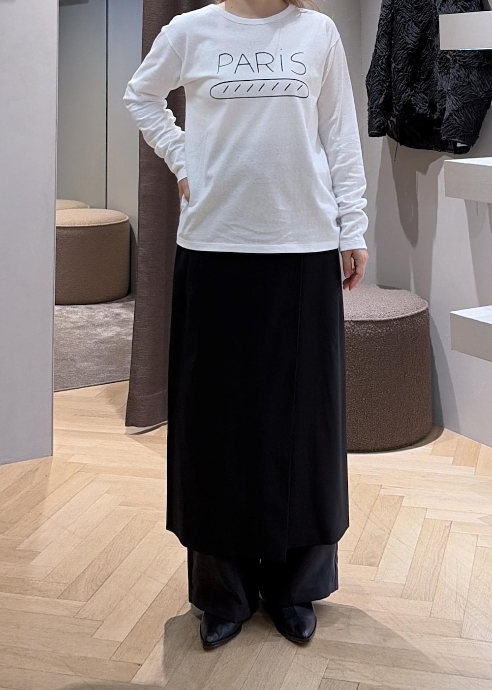 ブラック系のスカート、ホワイト系のTシャツ/カットソー、ベージュ系のショルダーバッグを着用したレディースの秋コーディネートの7枚目の写真
