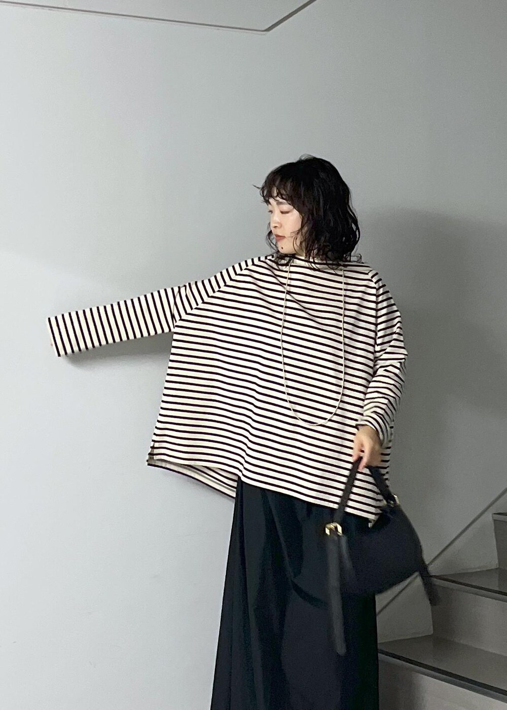 ブラック系のスカート、レッド系のカーディガン/ボレロ、ブラック系のショルダーバッグを着用したレディースの秋コーディネートの5枚目の写真