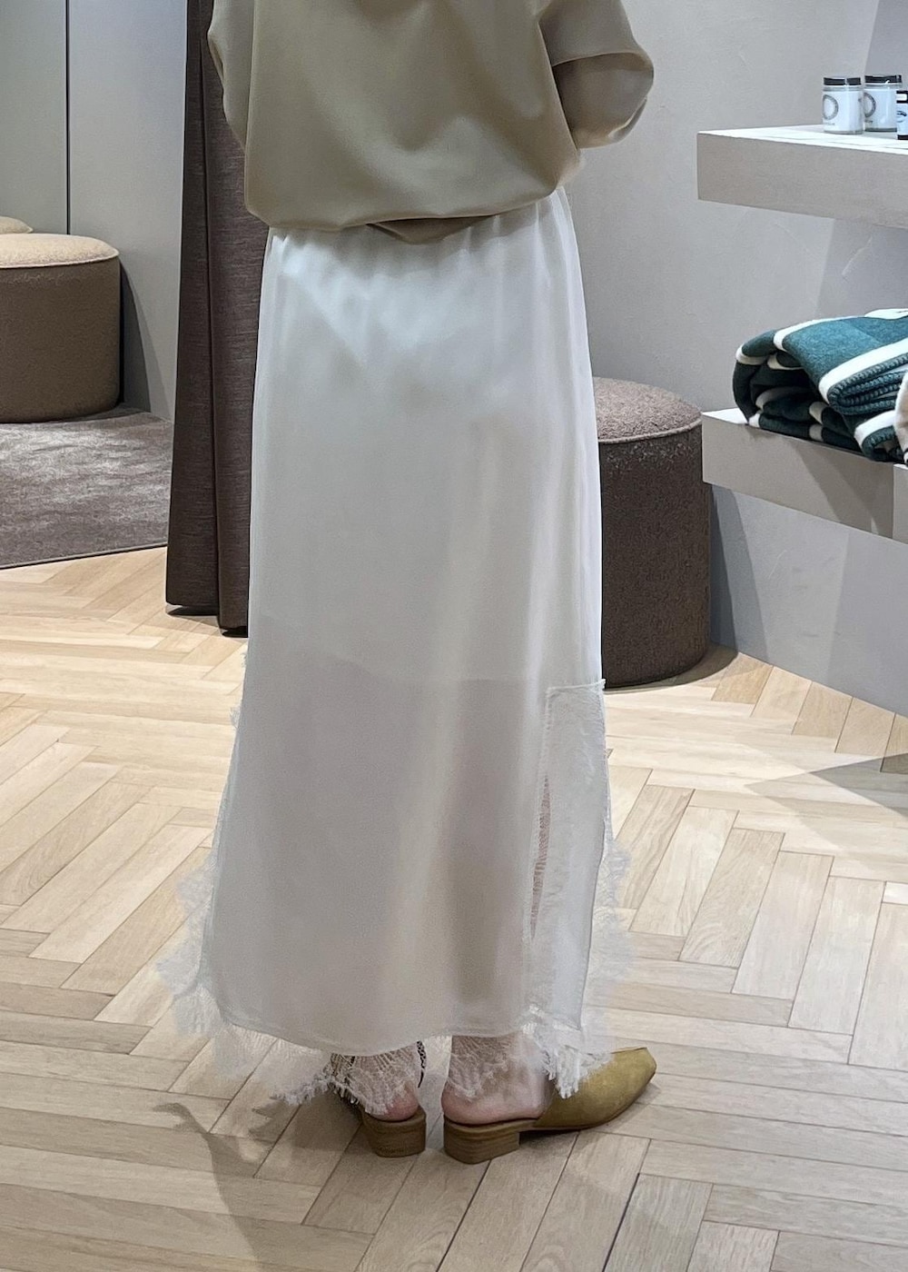 ベージュ系のスウェット、ブルー系のデニムパンツ、ホワイト系のスカートを着用したレディースの冬コーディネートの6枚目の写真