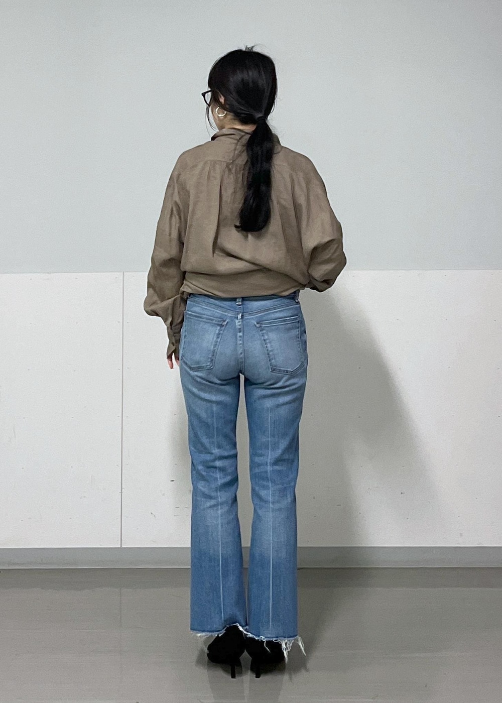 グリーン系のシャツ/ブラウス、ブラック系のショルダーバッグ、ブルー系のデニムパンツを着用したレディースの春コーディネートの3枚目の写真