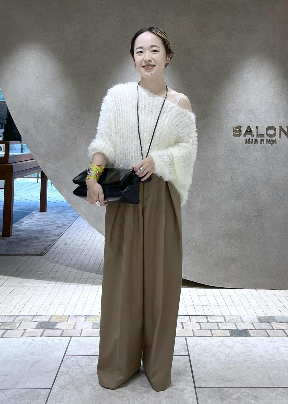 ベージュ系のスラックス、ベージュ系のチェスターコート、ホワイト系のニット/セーターを着用したレディースの秋コーディネートの7枚目の写真