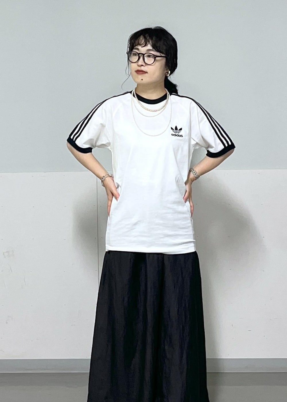 ブラック系のスカート、ゴールド系のサンダル、シルバー系のハンドバッグを着用したレディースの夏コーディネートの5枚目の写真