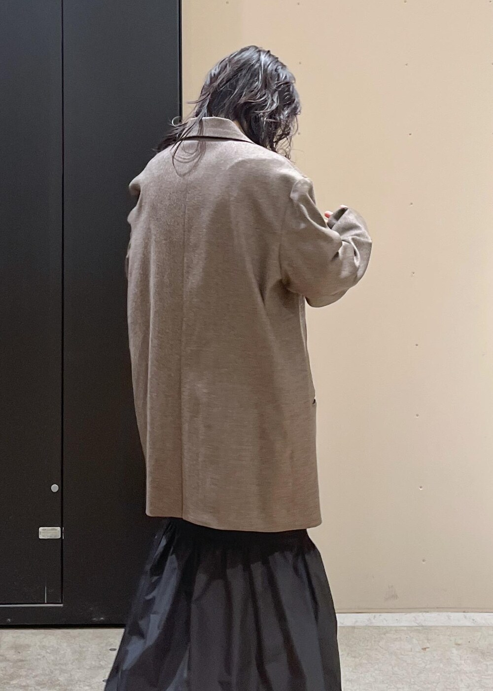 レッド系のニット/セーター、ブラウン系のテーラードジャケット、ブラウン系のショルダーバッグを着用したレディースの冬コーディネートの3枚目の写真