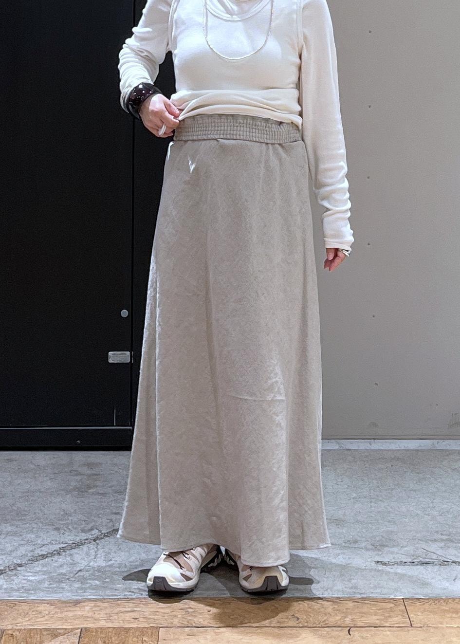 ベージュ系のスニーカー、ベージュ系のスカート、ホワイト系のタンクトップを着用したレディースの春コーディネートの5枚目の写真