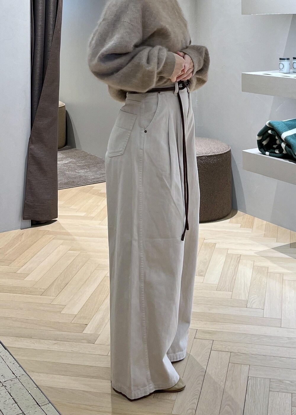 ブラウン系のショルダーバッグ、ベージュ系のニット/セーター、ホワイト系のデニムパンツを着用したレディースの冬コーディネートの5枚目の写真