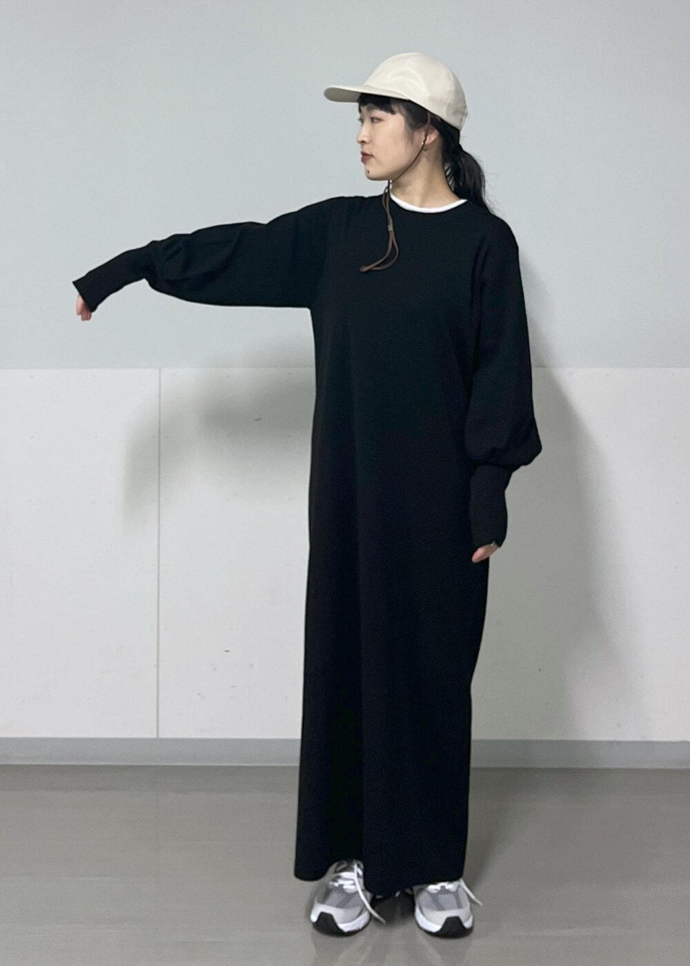 ホワイト系のTシャツ/カットソー、ブラック系のワンピース、グレー系のスニーカーを着用したレディースの秋コーディネートの4枚目の写真