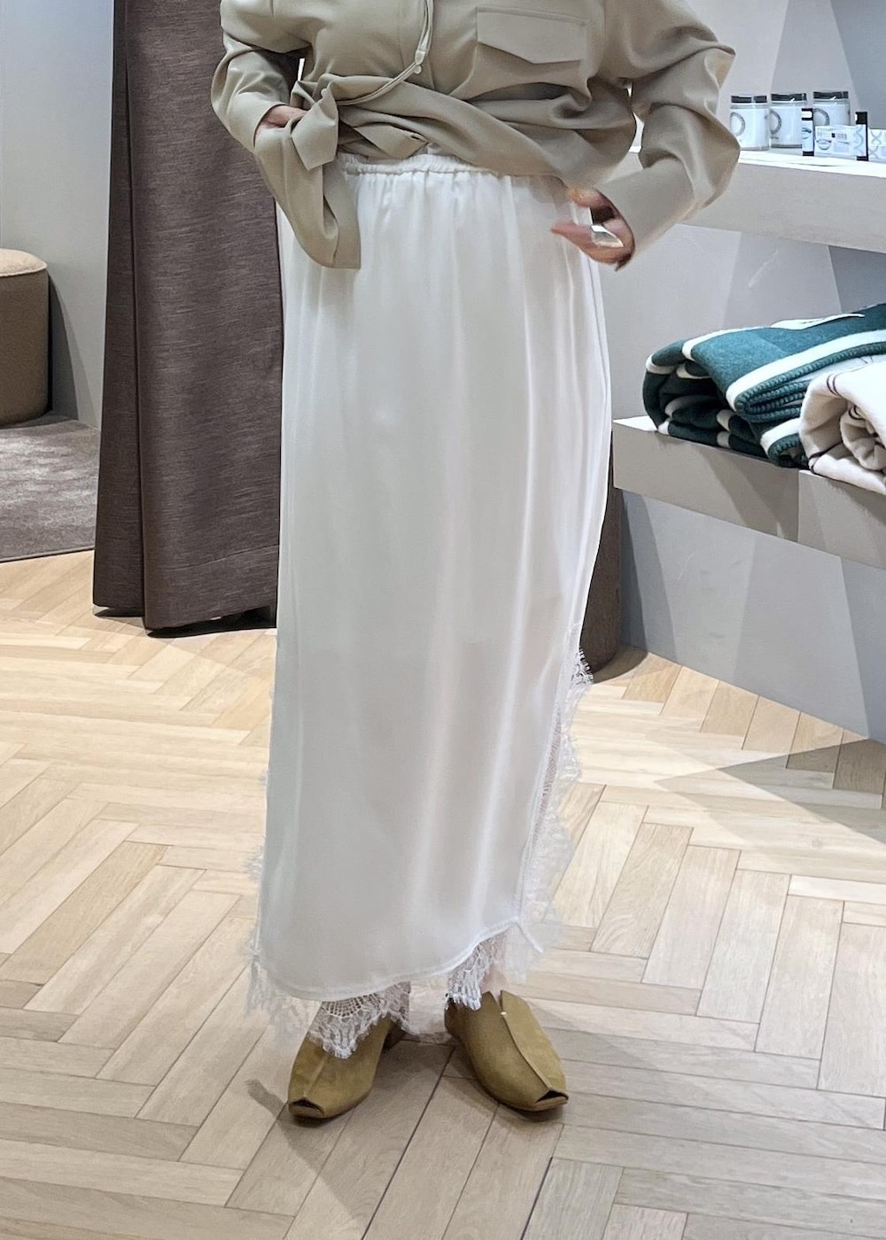 ベージュ系のスウェット、ブルー系のデニムパンツ、ホワイト系のスカートを着用したレディースの冬コーディネートの4枚目の写真