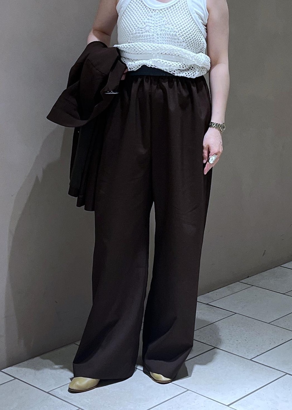 ブラック系のショルダーバッグ、ブラウン系のその他パンツ、ブルー系のニット/セーターを着用したレディースの春コーディネートの9枚目の写真