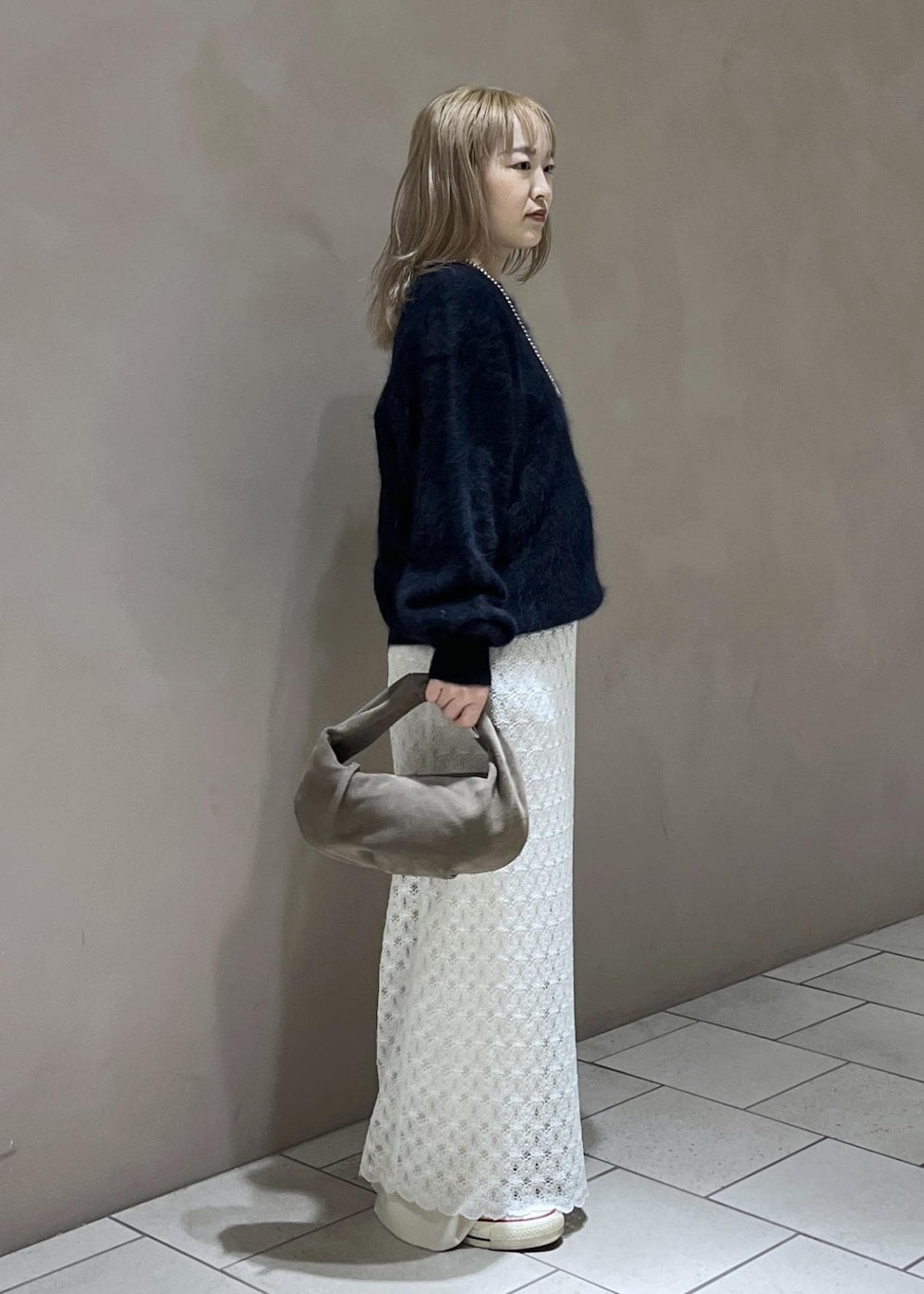 ホワイト系のスカート、ブルー系のニット/セーター、ホワイト系のスラックスを着用したレディースの秋コーディネートの2枚目の写真