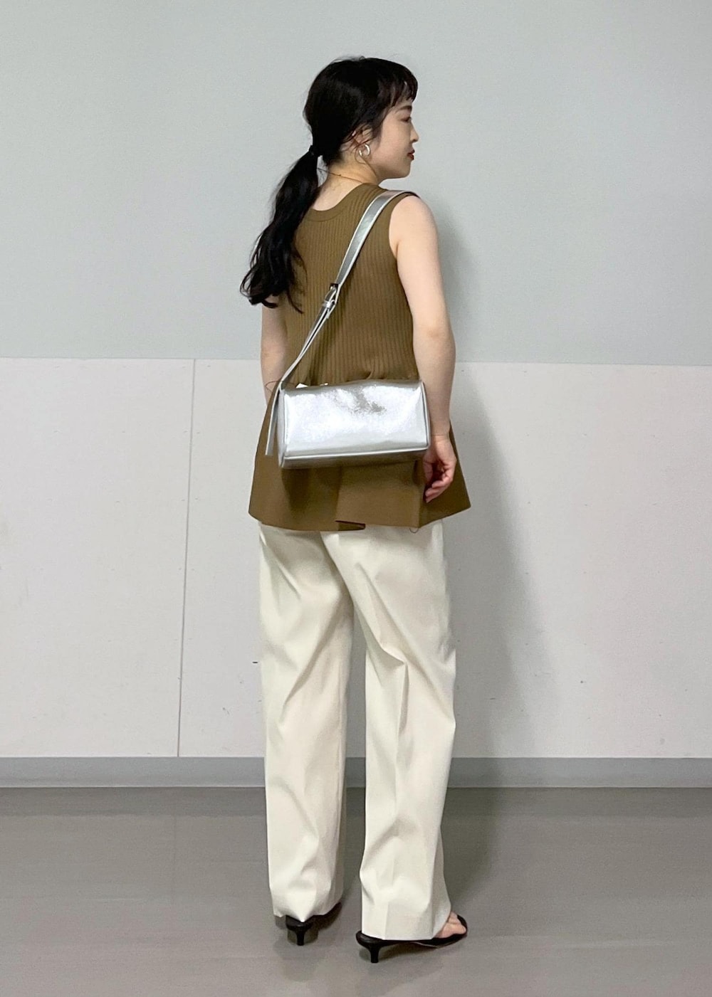 シルバー系のショルダーバッグ、ブラック系のサンダル、ホワイト系のその他パンツを着用したレディースの春コーディネートの4枚目の写真