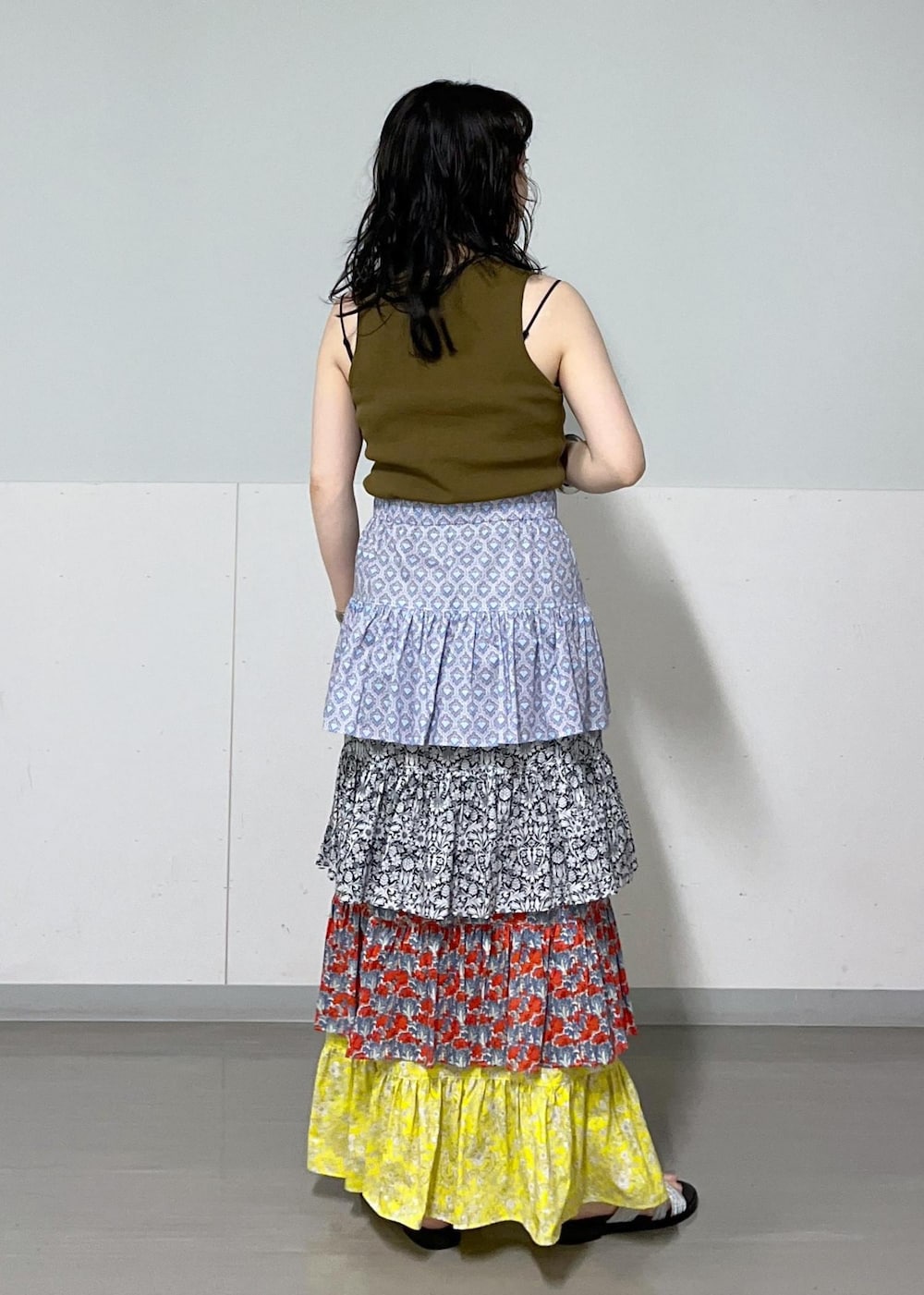 ブラック系のチューブトップ、ブラック系のサンダル、その他のスカートを着用したレディースの夏コーディネートの7枚目の写真