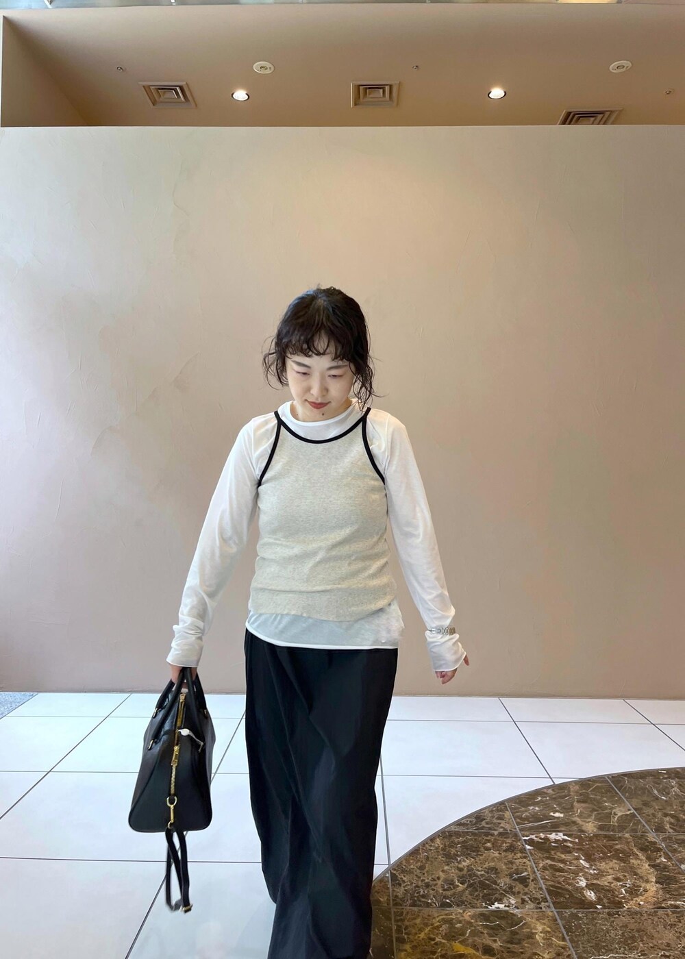 ブラック系のスカート、ベージュ系のタンクトップ、ホワイト系のTシャツ/カットソーを着用したレディースの夏コーディネートの6枚目の写真