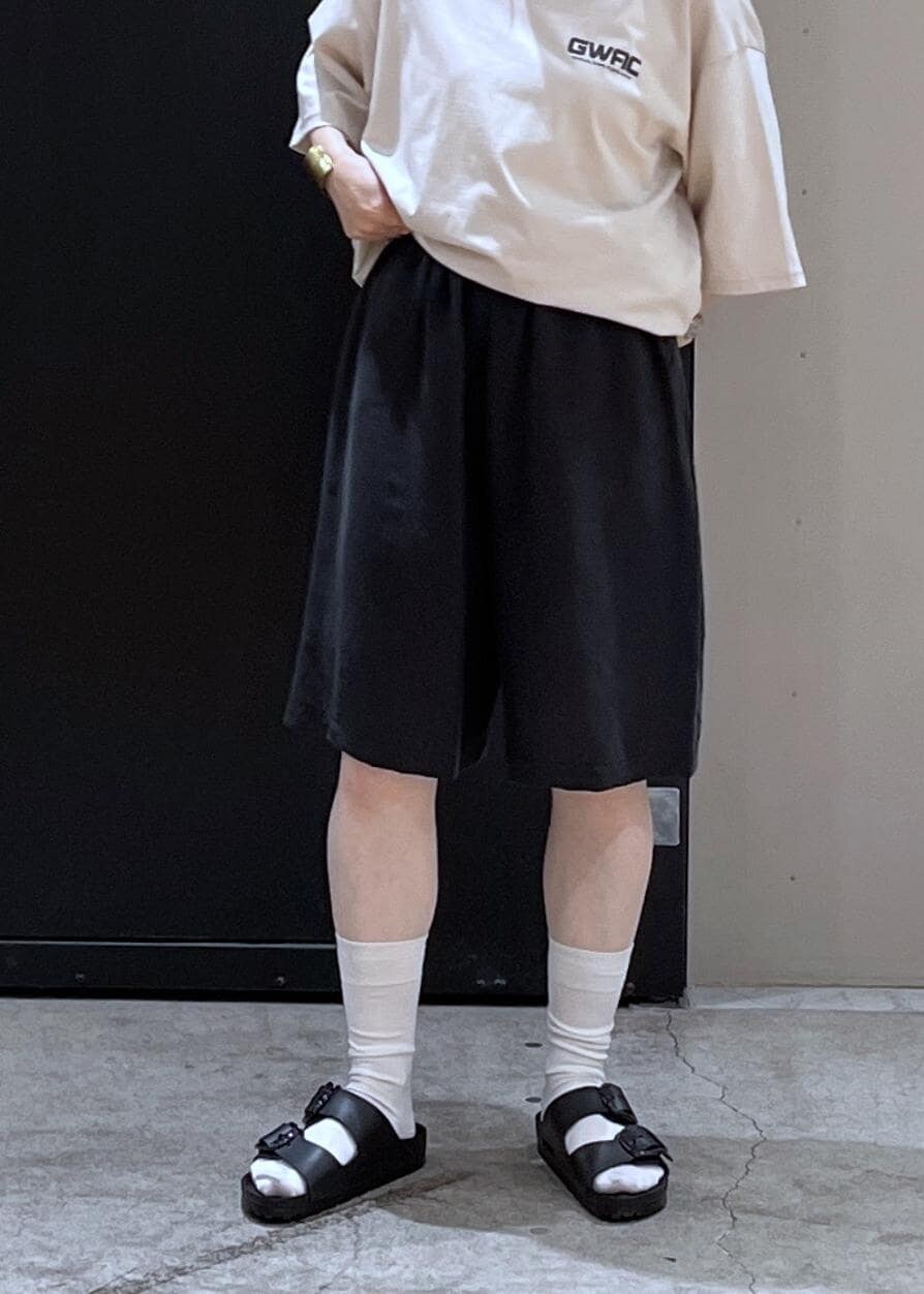 ブラック系のサンダル、ホワイト系のTシャツ/カットソー、ベージュ系のベストを着用したレディースの夏コーディネートの5枚目の写真