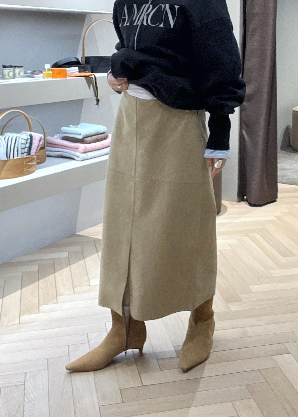 ベージュ系のスカート、ブラック系のショルダーバッグ、イエロー系のブーツを着用したレディースの冬コーディネートの5枚目の写真