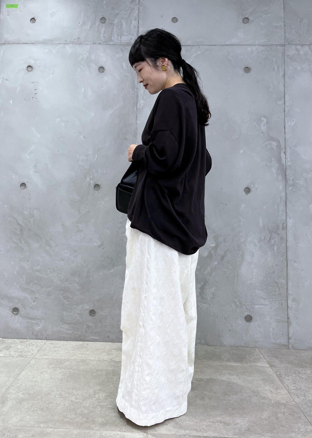 ブラック系のTシャツ/カットソー、ブラック系のハンドバッグ、ブラック系のブーツを着用したレディースの夏コーディネートの3枚目の写真