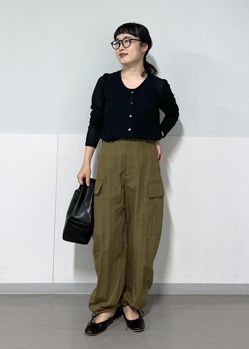 グリーン系のカーゴパンツ、ブラック系のハンドバッグ、ブラック系のカーディガン/ボレロを着用したレディースの夏コーディネートの2枚目の写真
