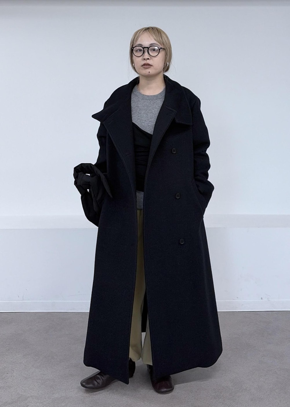 ベージュ系のその他パンツ、グレー系のダウンジャケット/コート、ブラック系のショルダーバッグを着用したレディースの秋コーディネートの5枚目の写真