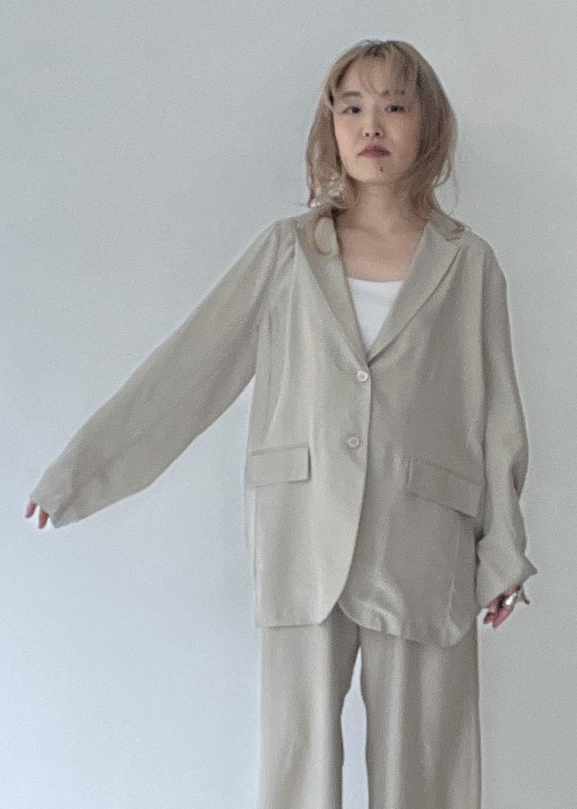 ベージュ系のテーラードジャケット、イエロー系のトートバッグ、ベージュ系のパンプスを着用したレディースの春コーディネートの4枚目の写真