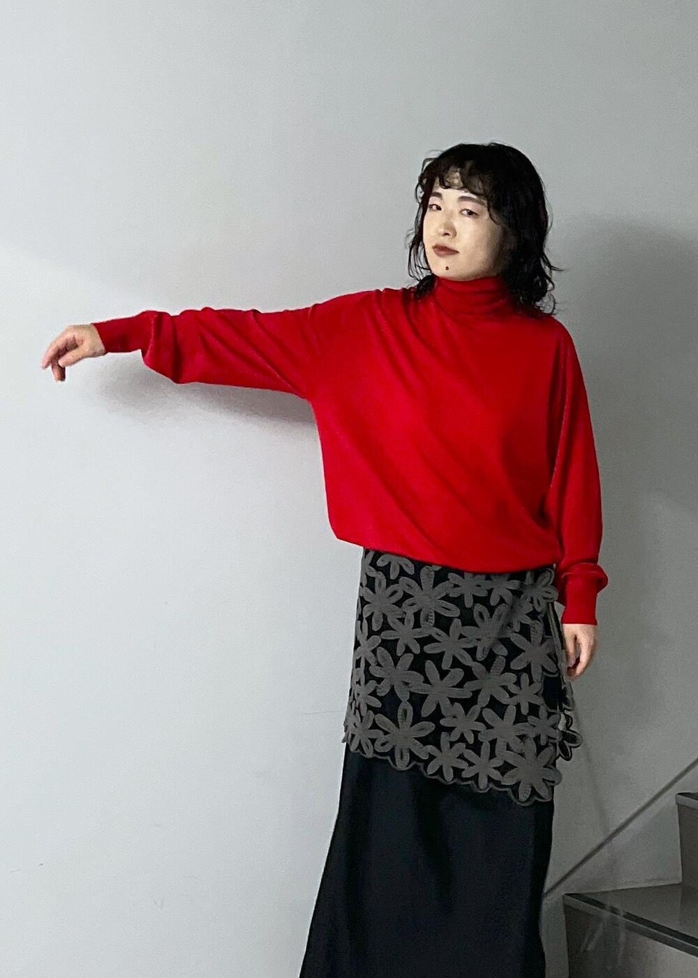 ブラック系のスカート、レッド系のニット/セーター、グレー系のスカートを着用したレディースの秋コーディネートの5枚目の写真