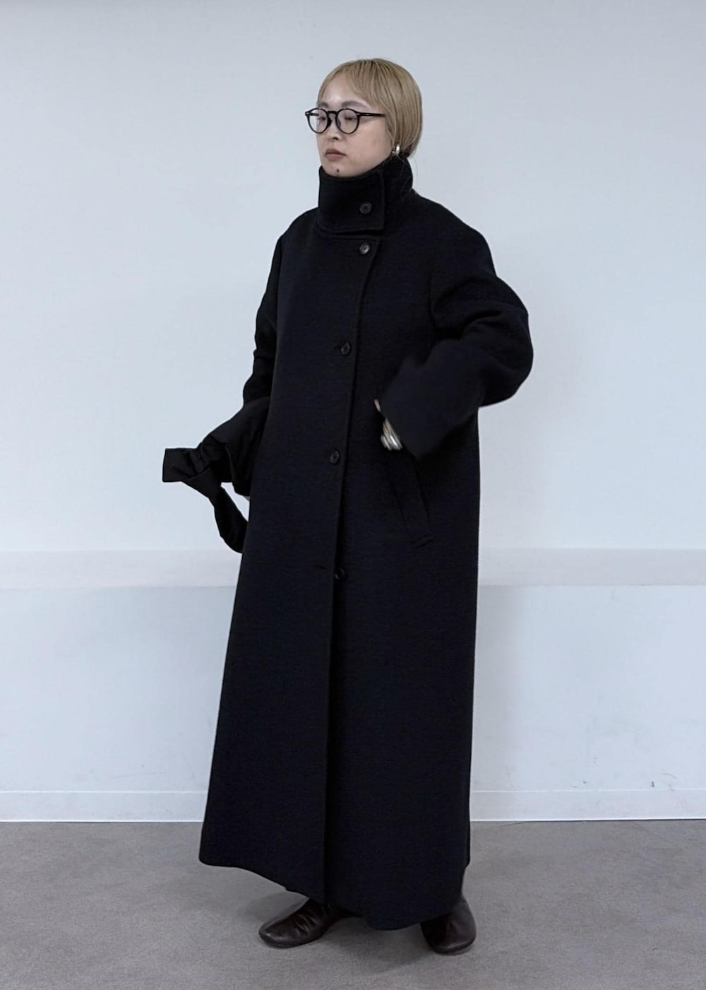 ベージュ系のその他パンツ、グレー系のダウンジャケット/コート、ブラック系のショルダーバッグを着用したレディースの秋コーディネートの3枚目の写真