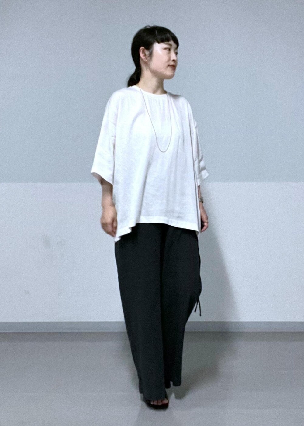 ホワイト系のTシャツ/カットソー、ブラック系のサンダル、ブラック系のその他パンツを着用したレディースの夏コーディネートの3枚目の写真