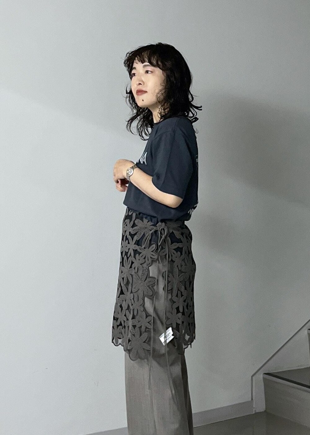 ブルー系のトートバッグ、グレー系のスラックス、ブラック系のTシャツ/カットソーを着用したレディースの秋コーディネートの6枚目の写真