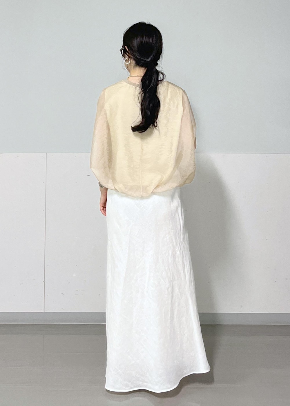 ブラック系のサンダル、ホワイト系のスカート、ベージュ系のTシャツ/カットソーを着用したレディースの春コーディネートの3枚目の写真