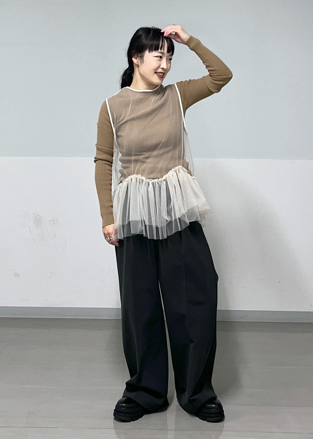 ブラック系のその他パンツ、ブラック系のブーツ、ホワイト系のベストを着用したレディースの秋コーディネートの2枚目の写真