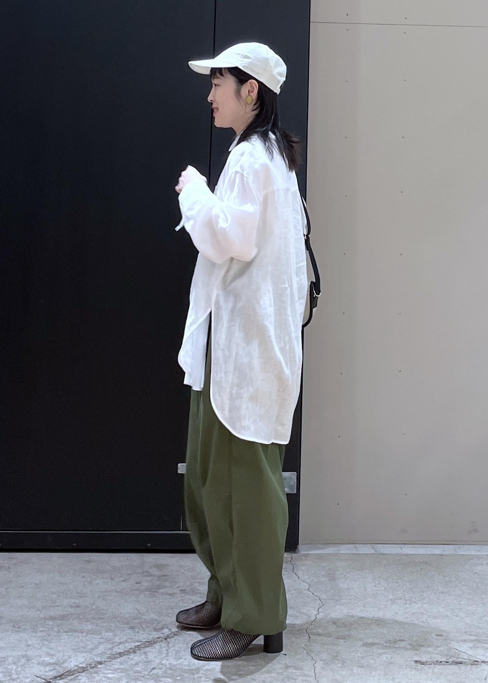 ホワイト系のシャツ/ブラウス、グリーン系のカーゴパンツ、ブラック系のブーツを着用したレディースの春コーディネートの2枚目の写真