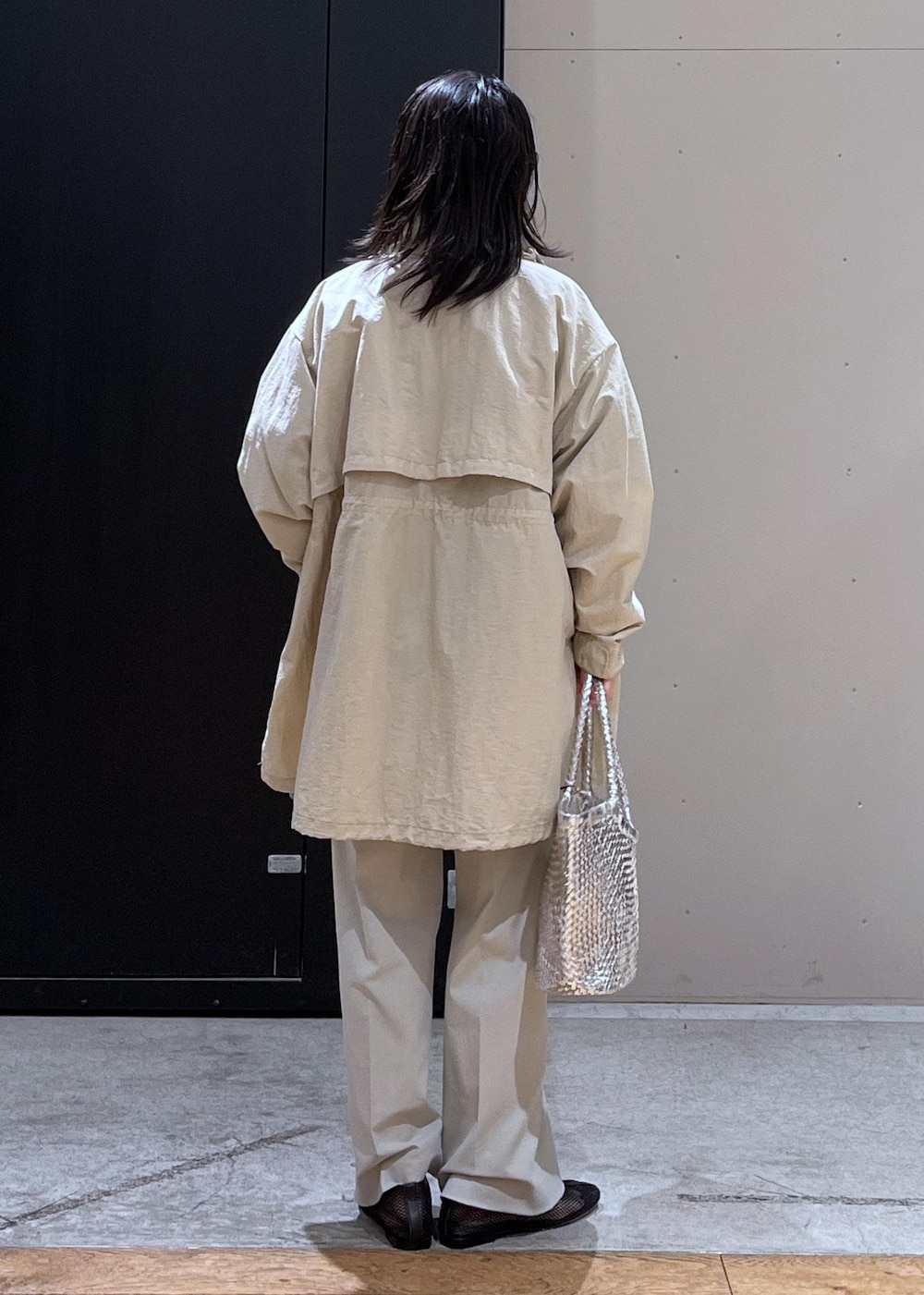 グレー系のスラックス、ベージュ系のブルゾン、ブラック系のパンプスを着用したレディースの春コーディネートの6枚目の写真