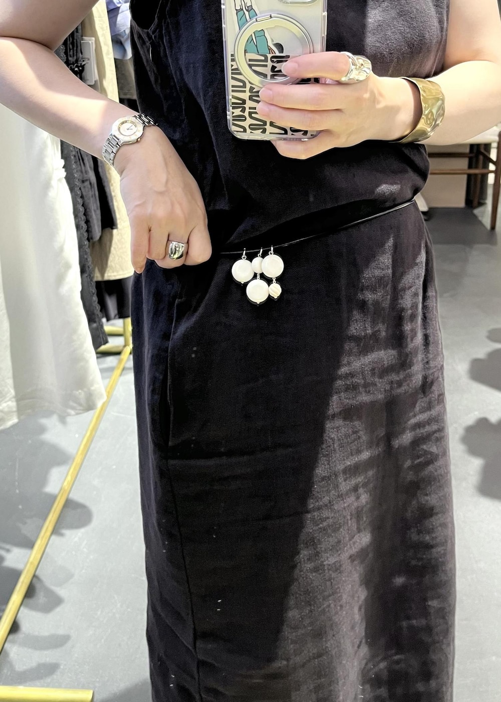 ブラック系のチューブトップ、ブラック系のサンダル、ブラウン系のカーディガン/ボレロを着用したレディースの夏コーディネートの9枚目の写真