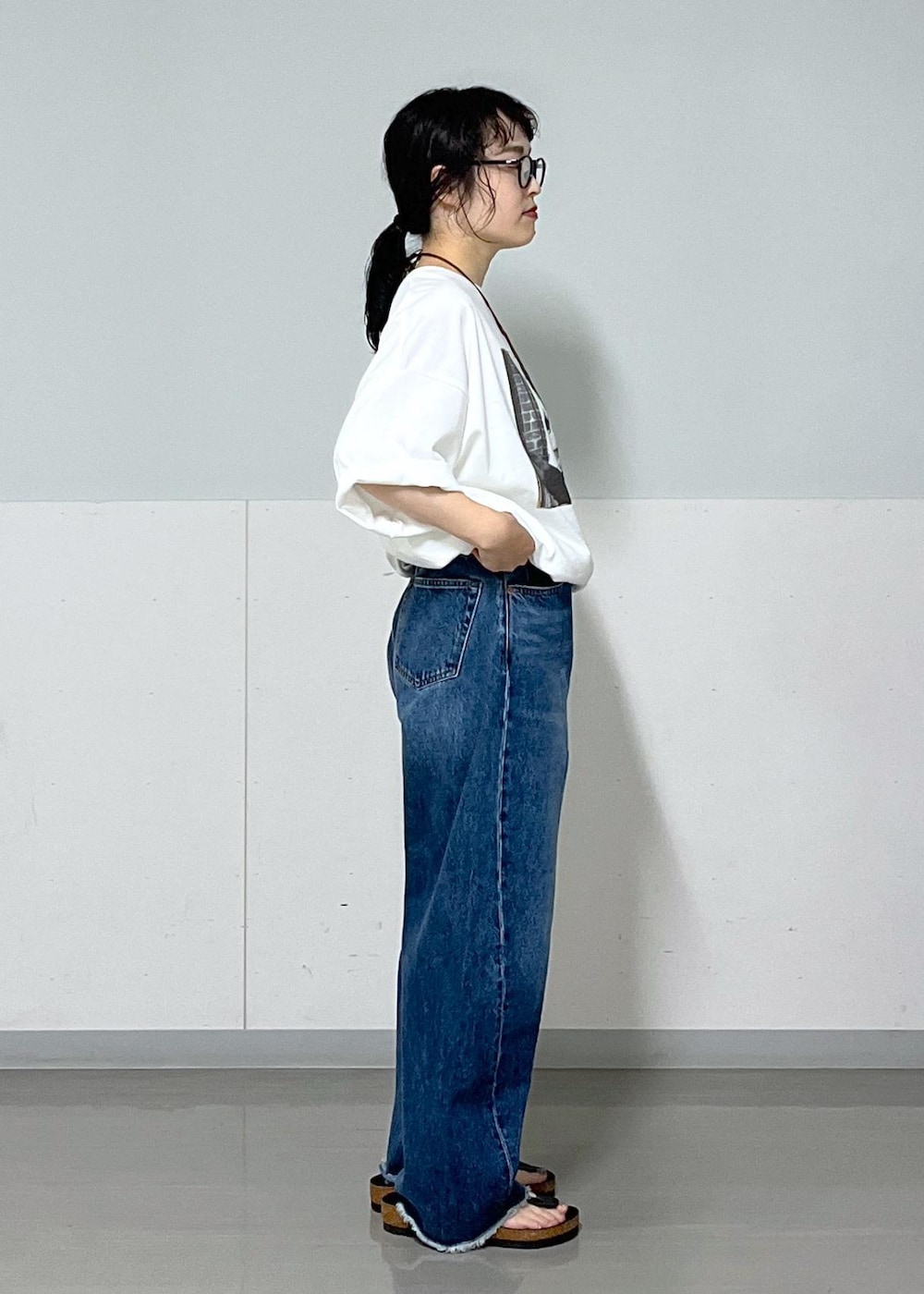 ブラック系のトートバッグ、ブルー系のデニムパンツ、ホワイト系のTシャツ/カットソーを着用したレディースの夏コーディネートの8枚目の写真