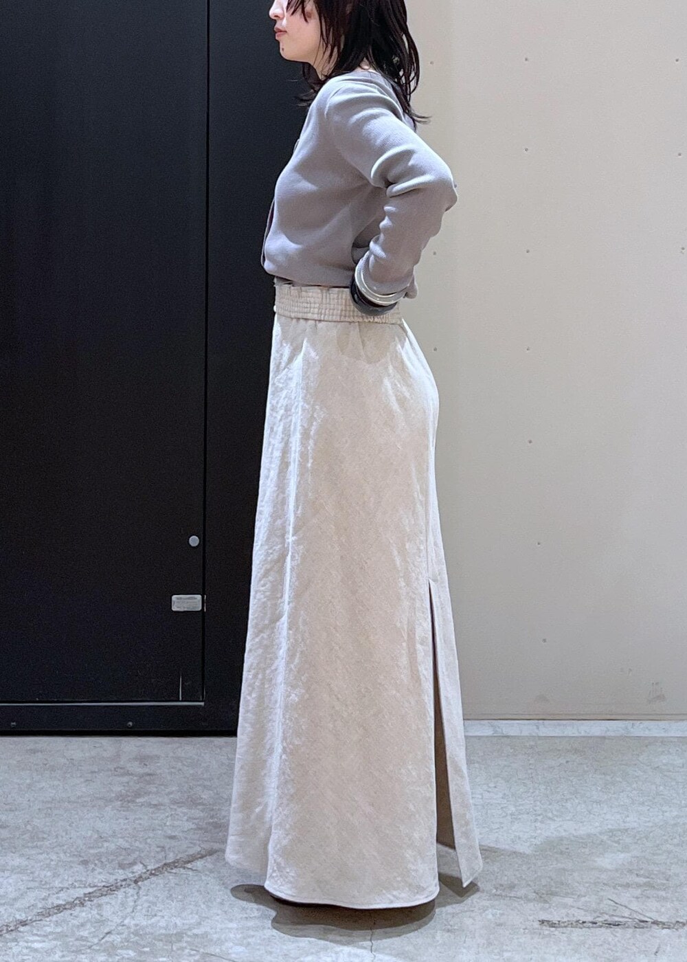 ブラック系のボストンバッグ、ベージュ系のパンプス、ベージュ系のスカートを着用したレディースの冬コーディネートの9枚目の写真