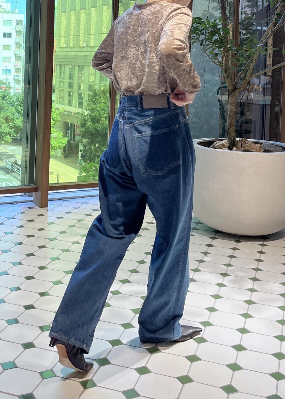 ベージュ系のショルダーバッグ、ブラック系のダウンジャケット/コート、ブルー系のデニムジャケットを着用したレディースの秋コーディネートの7枚目の写真