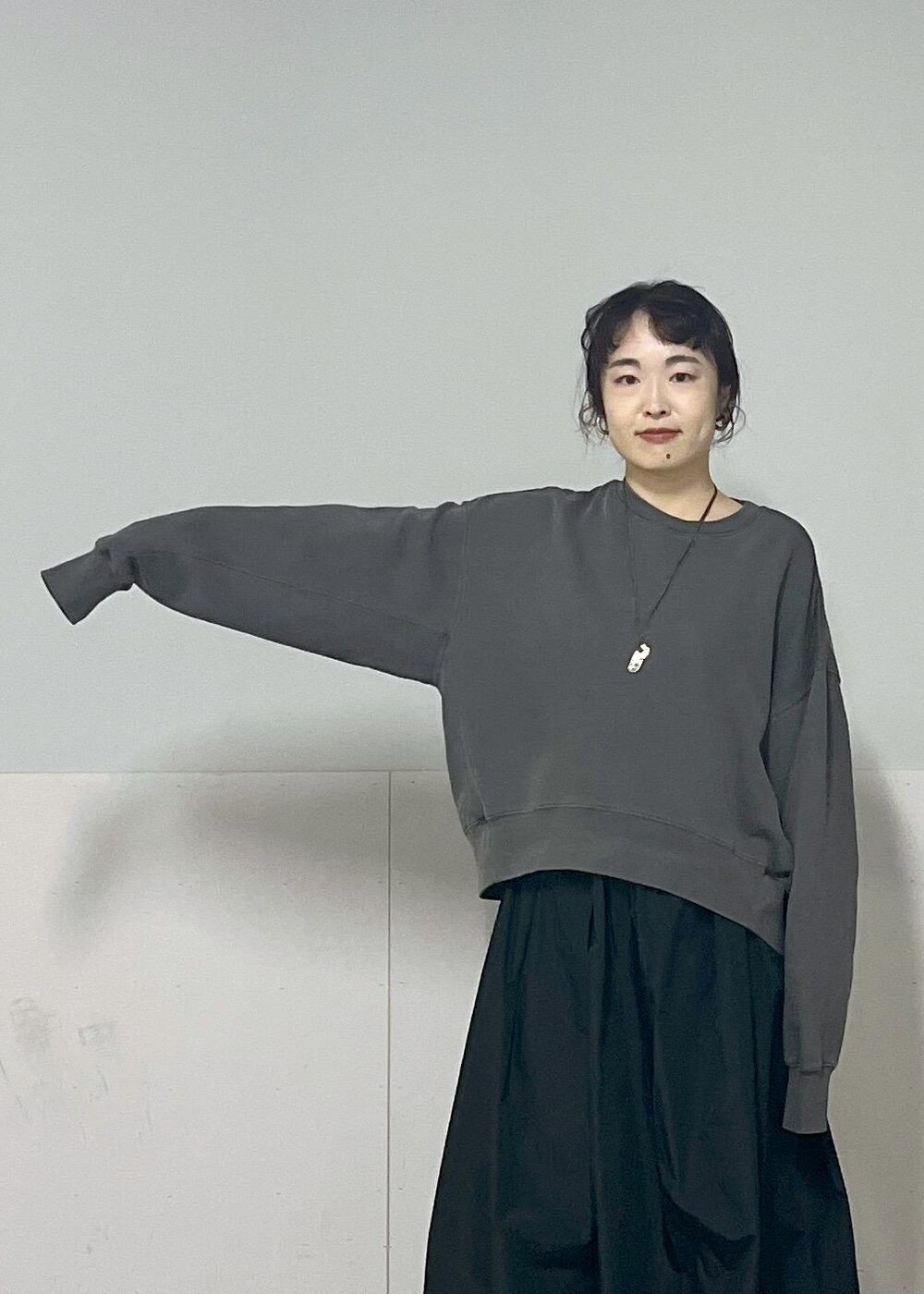 ブラック系のボディバッグ/ウエストポーチ、グレー系のスウェット、ブラック系のスカートを着用したレディースの秋コーディネートの6枚目の写真