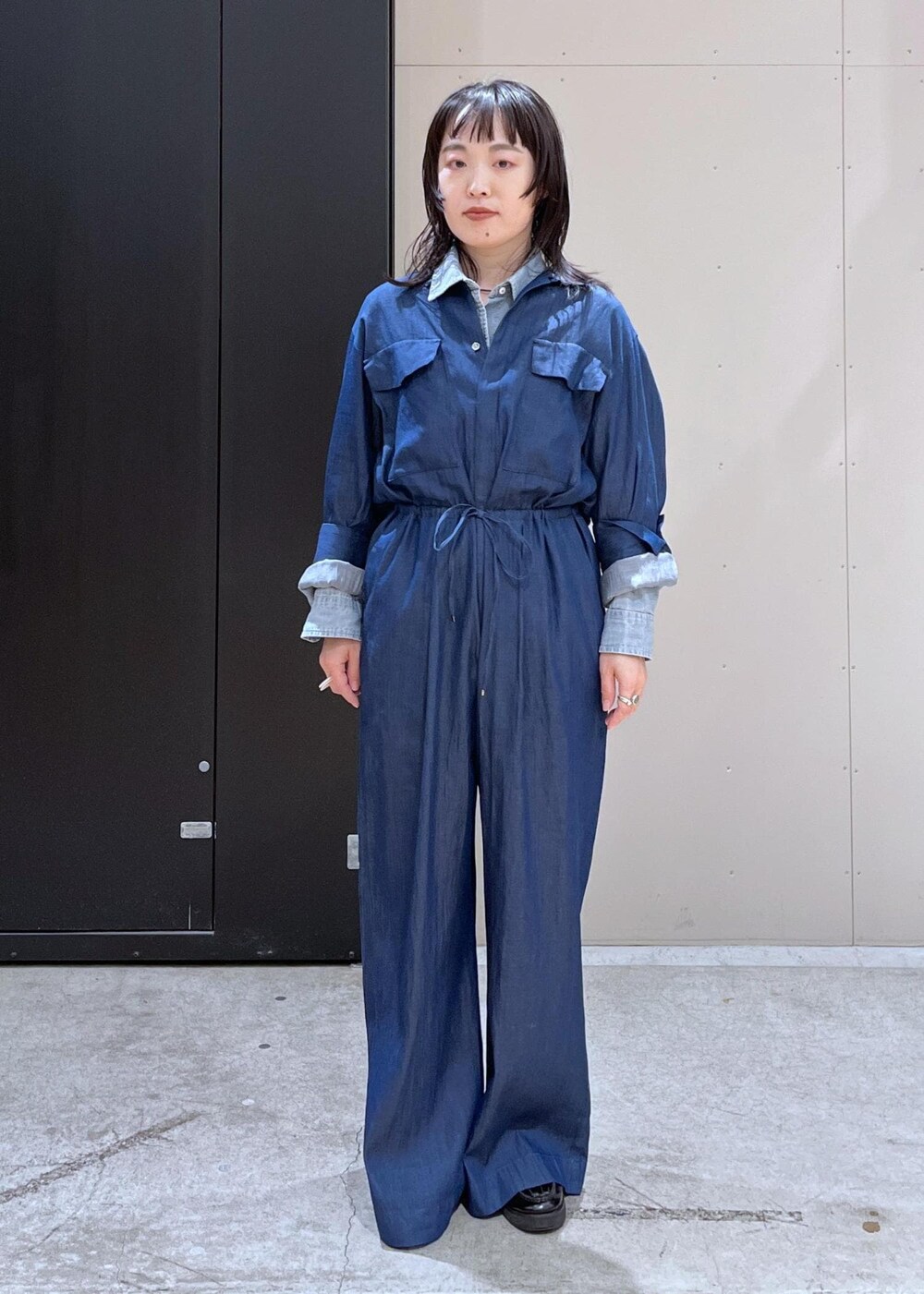 グレー系のショルダーバッグ、ブルー系のつなぎ/オールインワン、ブルー系のTシャツ/カットソーを着用したレディースの冬コーディネートの4枚目の写真