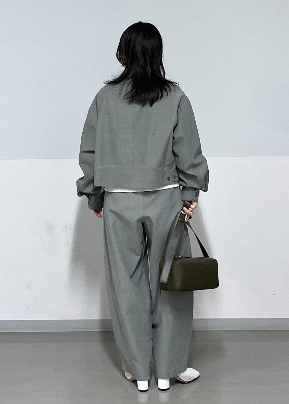 ブラック系のショルダーバッグ、グリーン系のブルゾン、グリーン系のその他パンツを着用したレディースの春コーディネートの3枚目の写真