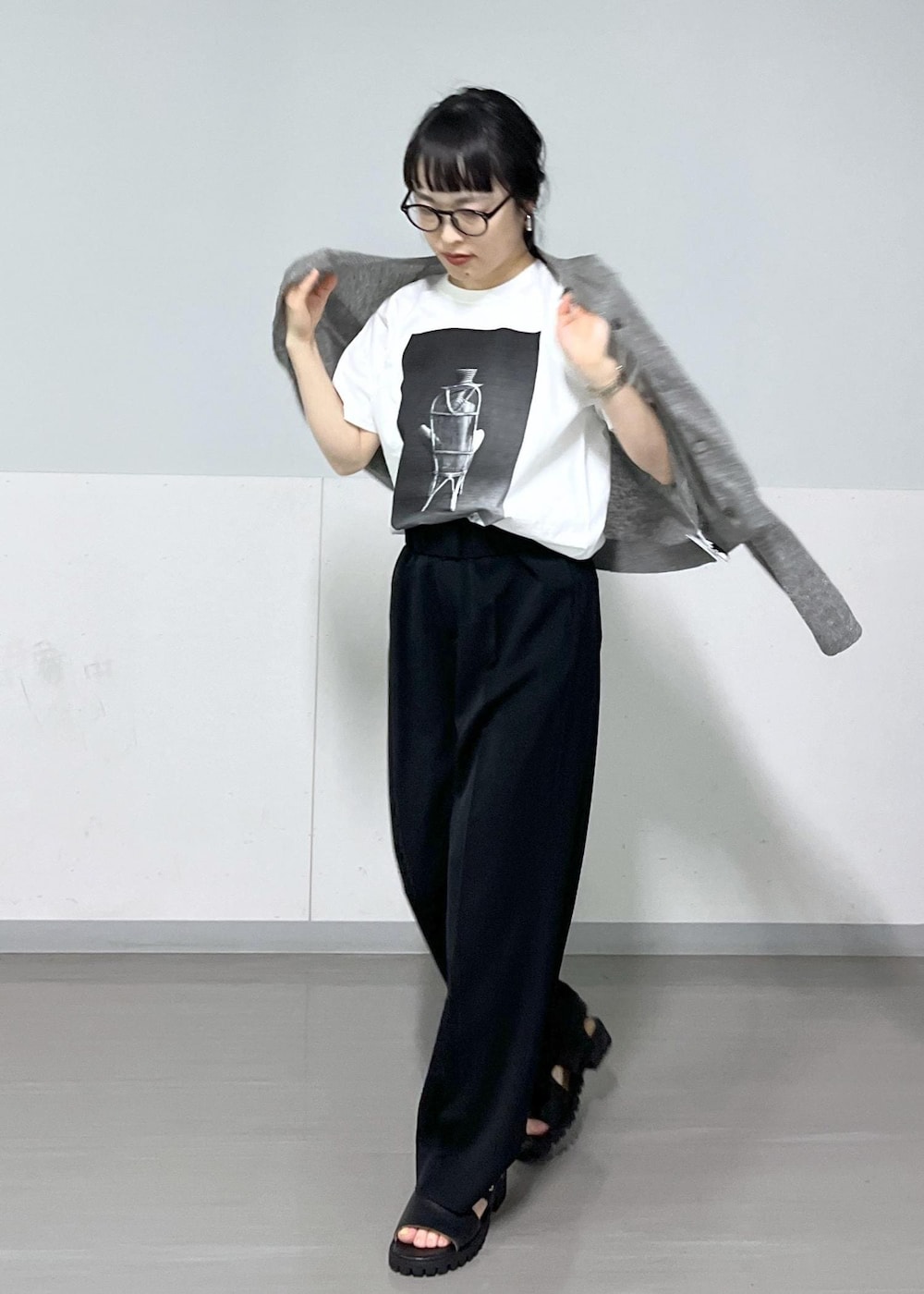 ブラック系のサンダル、グレー系のカーディガン/ボレロ、ブラック系のスラックスを着用したレディースの春コーディネートの5枚目の写真