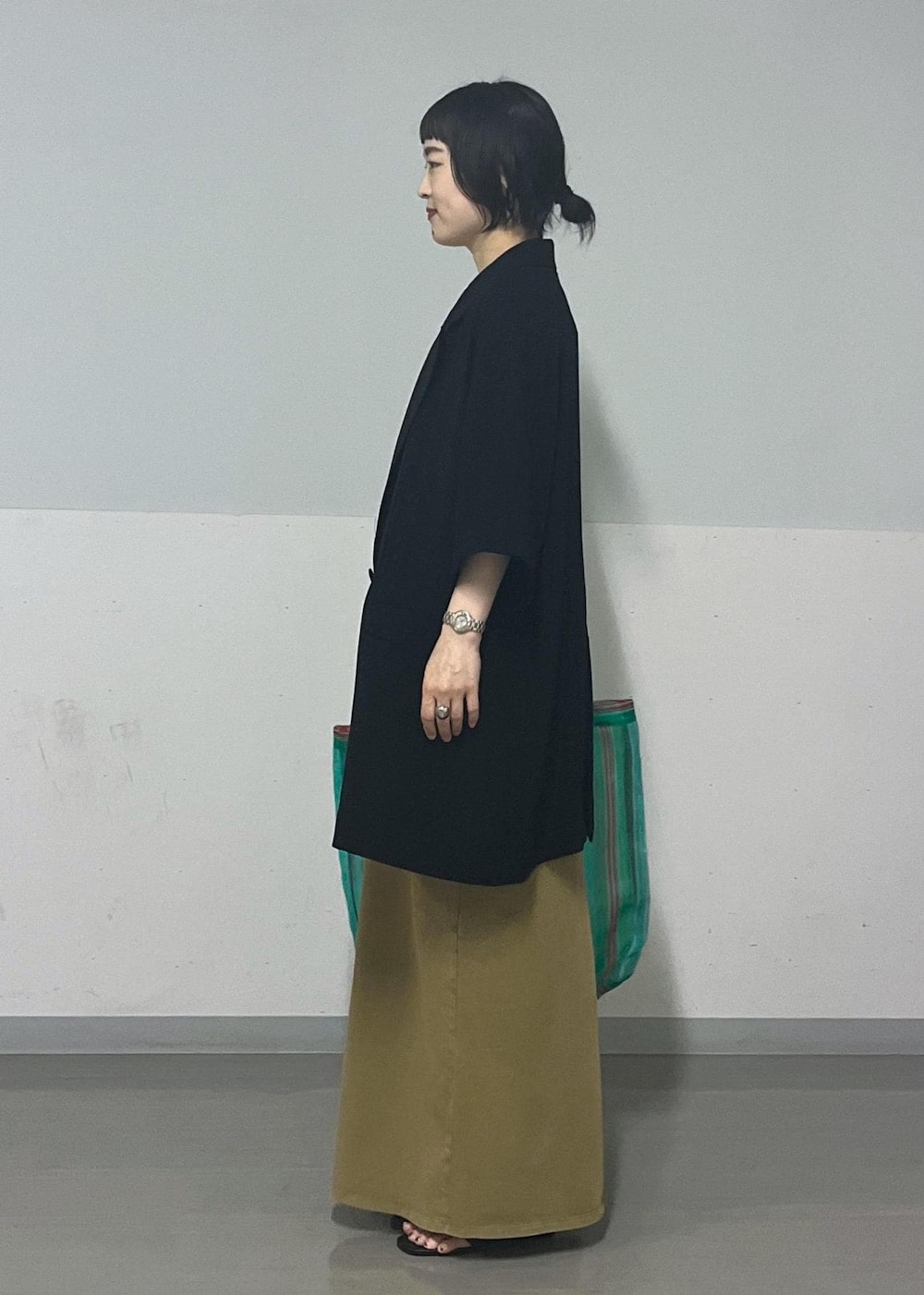 ブラック系のサンダル、ブラック系のテーラードジャケット、ブラウン系のワンピースを着用したレディースの夏コーディネートの2枚目の写真