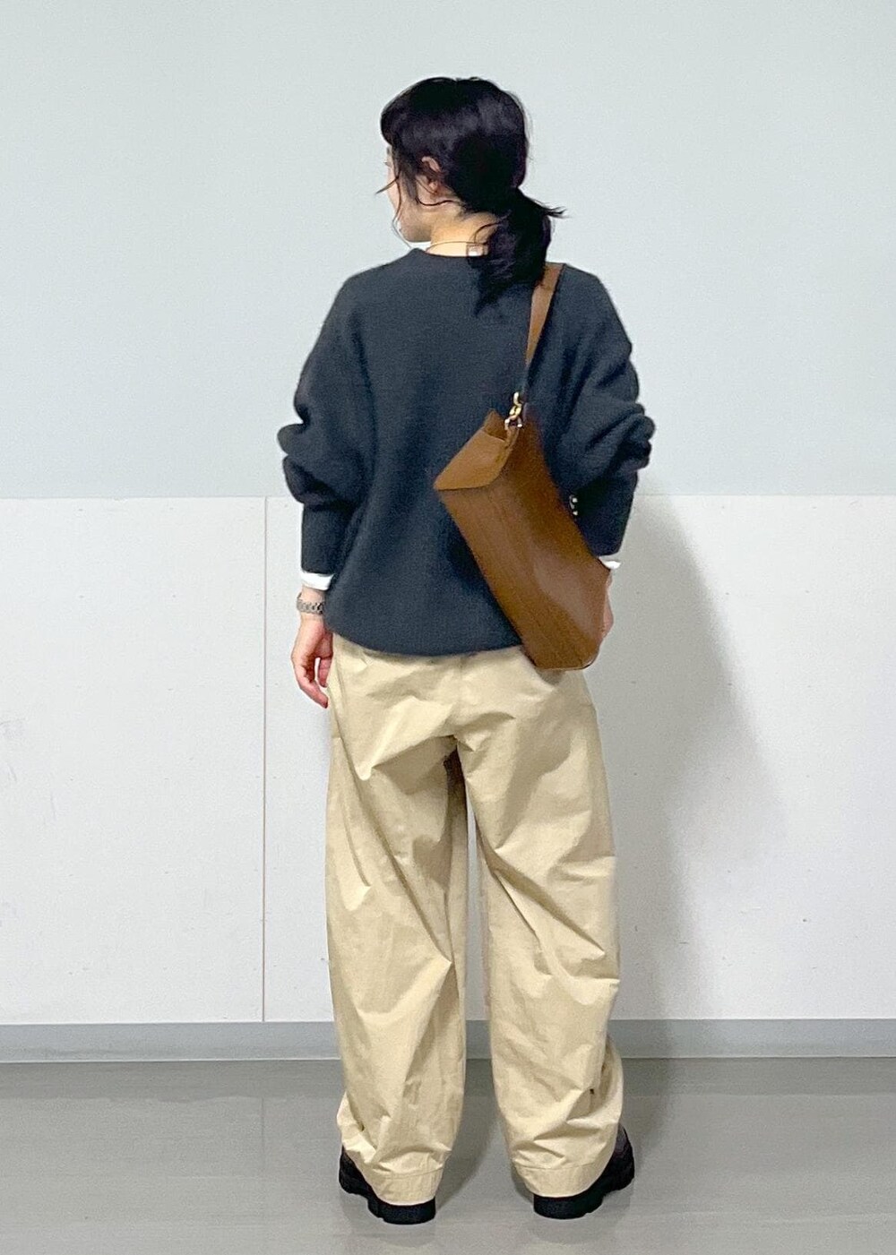 ホワイト系のTシャツ/カットソー、ブラウン系のショルダーバッグ、グレー系のニット/セーターを着用したレディースの秋コーディネートの3枚目の写真