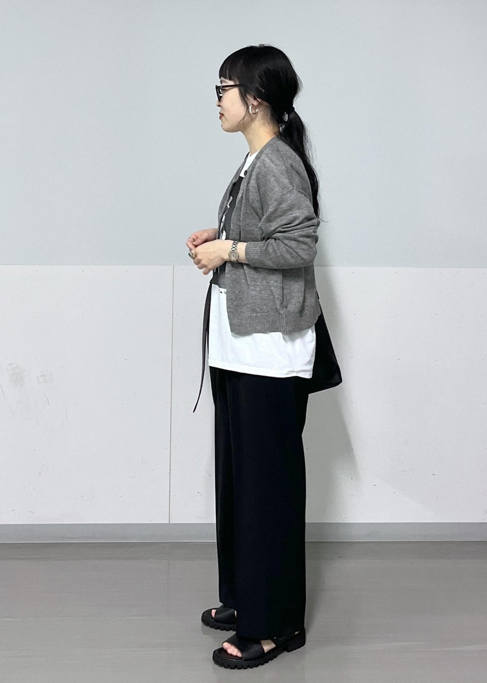 ブラック系のサンダル、グレー系のカーディガン/ボレロ、ブラック系のスラックスを着用したレディースの春コーディネートの4枚目の写真
